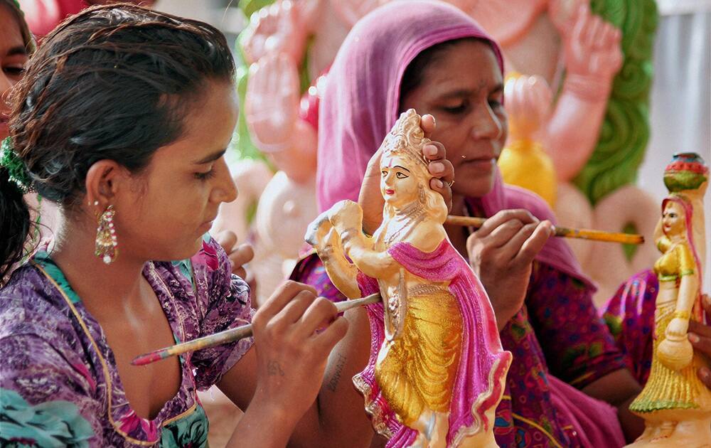 Ahead of Janmashtami, an artist imparts finishing touches to an idol of Lord Krishna in Bikaner.