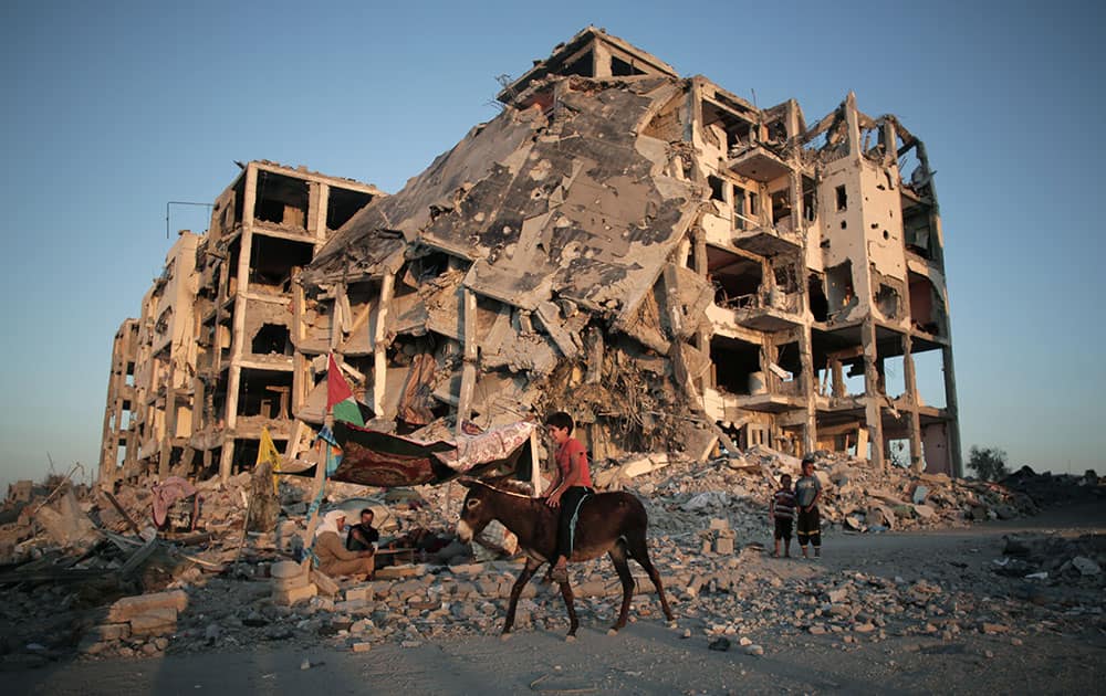 A Palestinian boy rides a donkey next to the destroyed Nada Towers residential neighborhood in the town of Beit Lahiya, northern Gaza Strip.