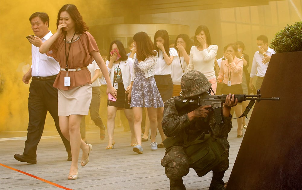 People evacuate from a building during a civil defense drill against possible attacks by North Korea as part of Ulchi Freedom Guardian exercise in Seoul, South Korea.