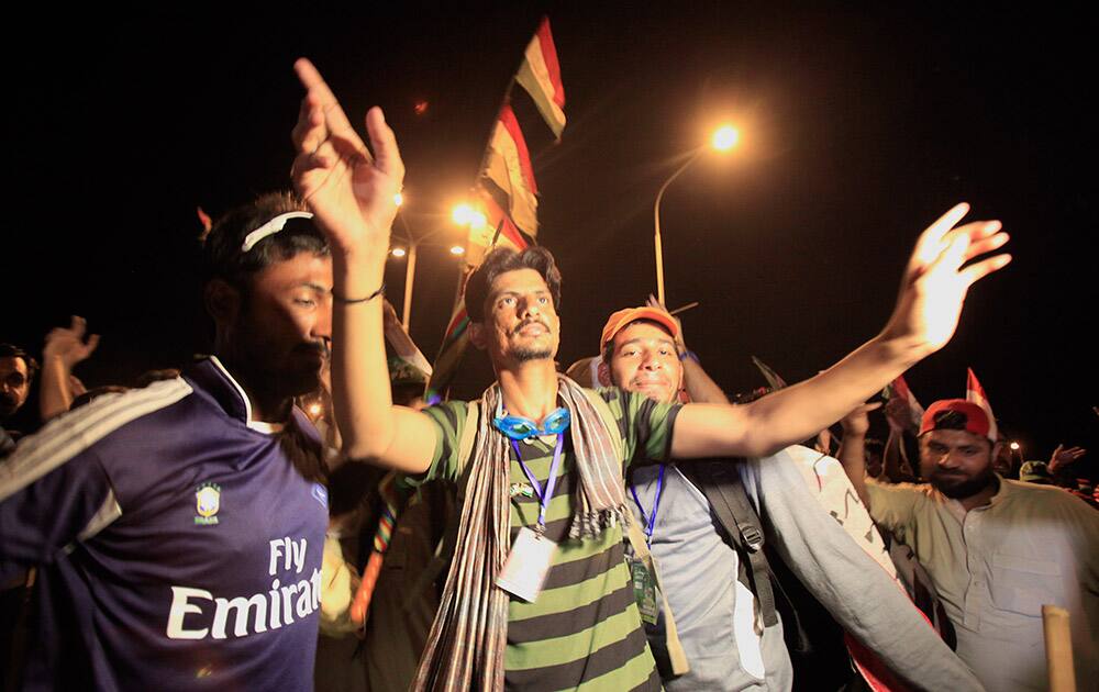 Supporters of Pakistani religious cleric Tahir-ul-Qadri dance during a march in front of The Parliament building in Islamabad.