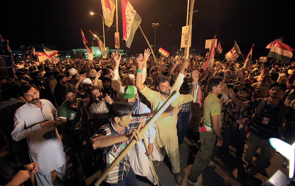 Thousands of supporters of anti-government cleric Tahir-ul-Qadri dance during a march in front of parliament building in Islamabad.