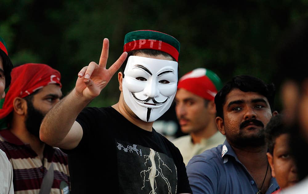 A supporter of Pakistan`s cricketer-turned-politician Imran Khan makes victory sign prior to march toward parliament in Islamabad, Pakistan.