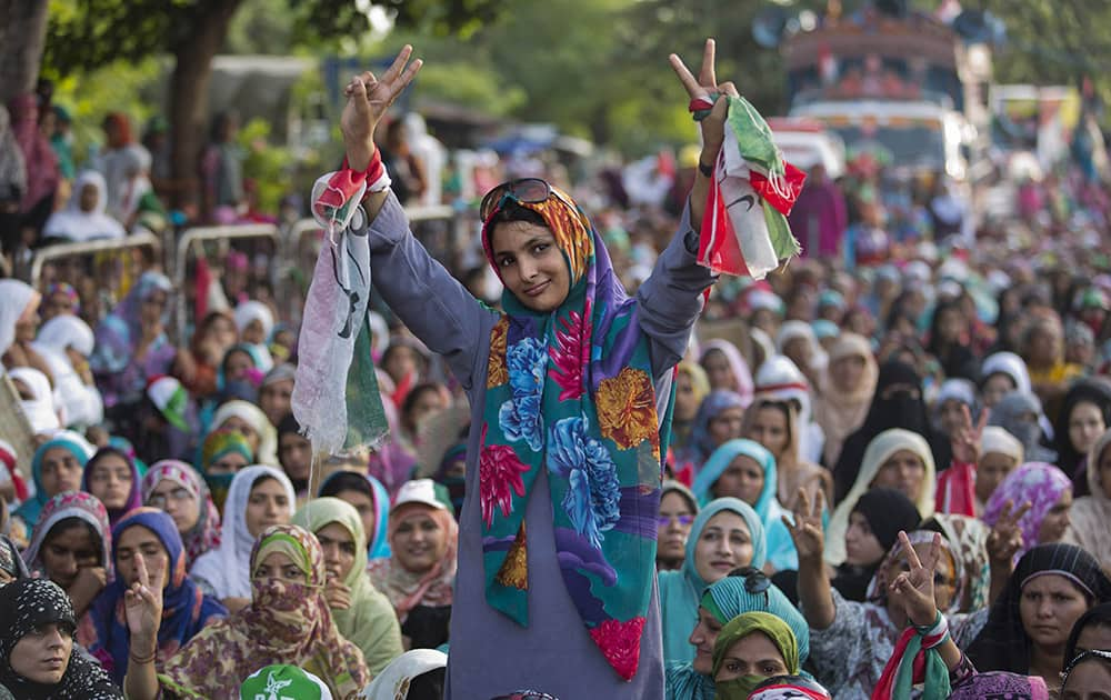 A supporter of Pakistani religious cleric Tahir-ul-Qadri flashes victory signs during an anti-government protest in Islamabad, Pakistan.