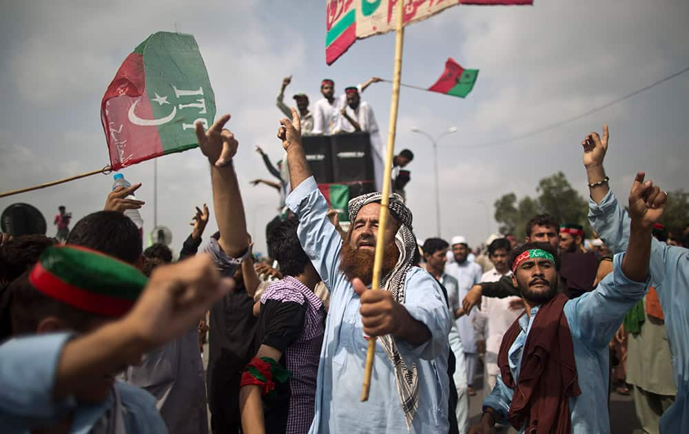 Supporters of Pakistan`s cricketer-turned-politician Imran Khan, chant slogans, while waiting for other supporters marching to Islamabad from Lahore, in Islamabad.