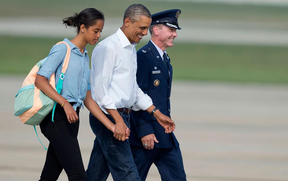 President Barack Obama and his daughter Malia Obama are escorted by 11th Wing and Installation Commander, Col. Brad Hoagland, as they walk to board Air Force One at Andrews Air Force Base, Md.