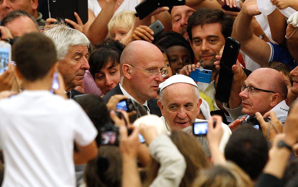 Pope Francis greets faithful as he arrives for his weekly general audience in the Paul VI hall, at the Vatican.