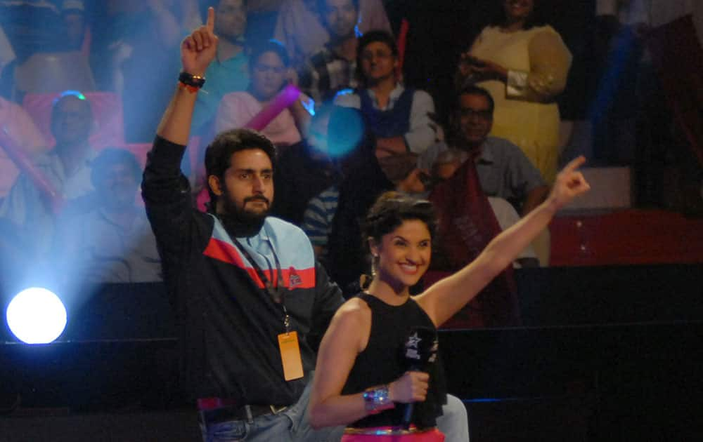 Abhishek Bachchan dances with the anchor after his team's win. DNA