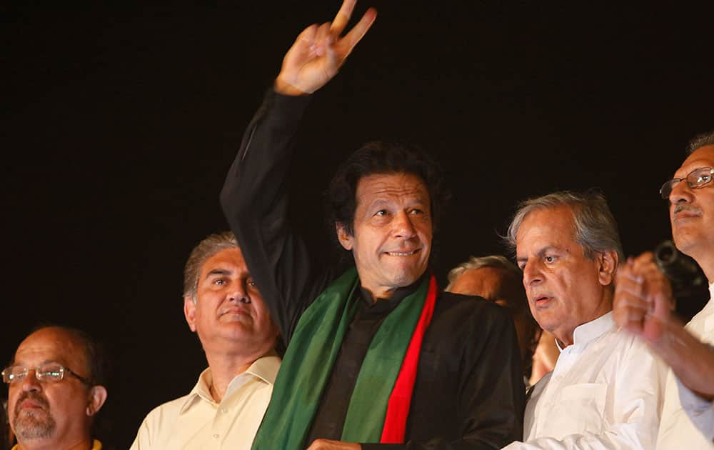 Pakistan`s cricketer-turned-politician Imran Khan flashes victory sign to his supporters near the parliament area in Islamabad, Pakistan.