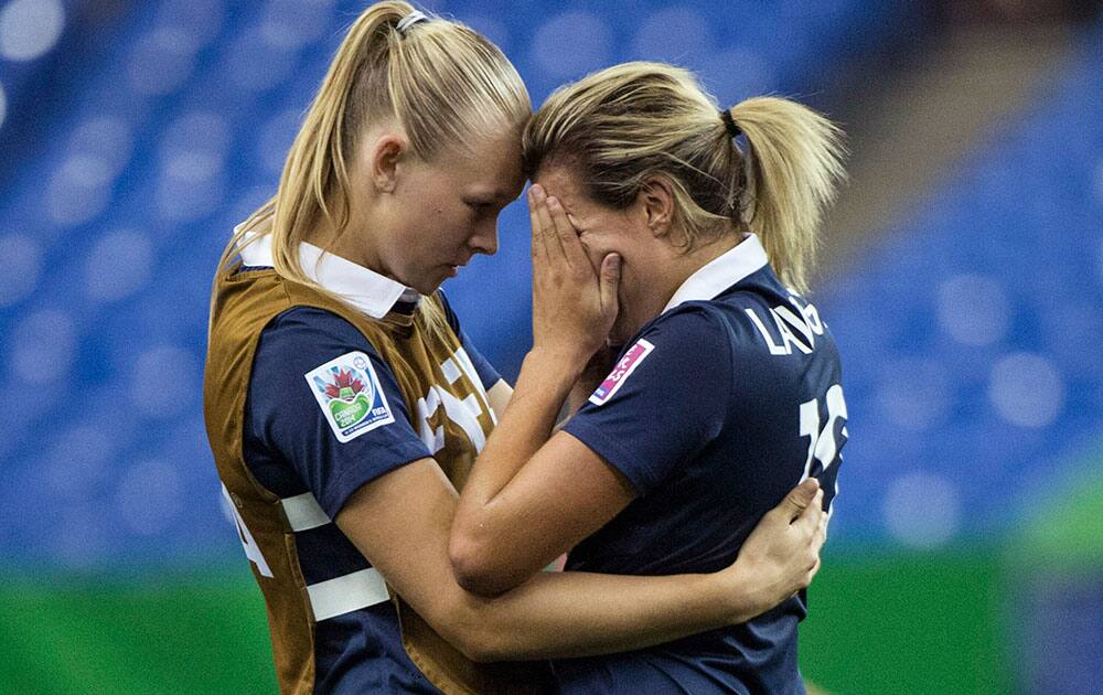 France`s Claire Lavogez, right, is consoled by teammate Charlotte Saint Sans after the team`s 2-1 loss to Germany in a FIFA U-20 women`s World Cup semifinal in Montreal.