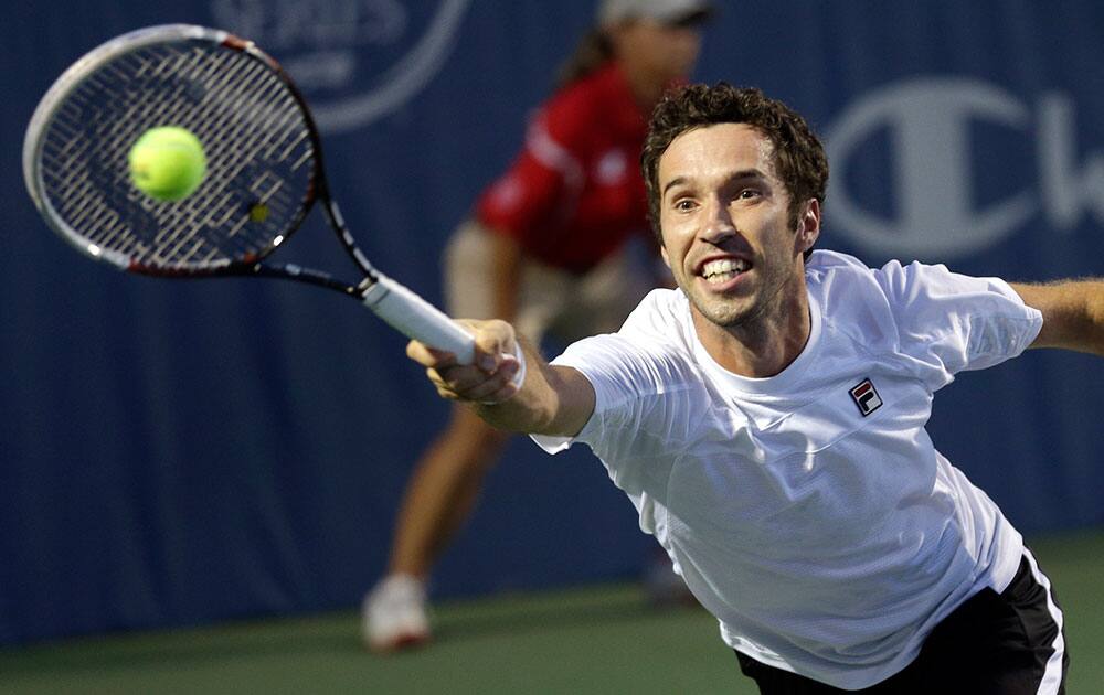 Mikhail Kukushkin, of Kazakhstan, reaches for a serve by John Isner, of the United States, at the Winston-Salem Open tennis tournament in Winston-Salem, N.C.