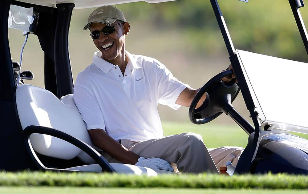 President Barack Obama smiles as he sits at the wheel of a golf cart while golfing at Vineyard Golf Club in Edgartown, Mass., on the island of Martha`s Vineyard.