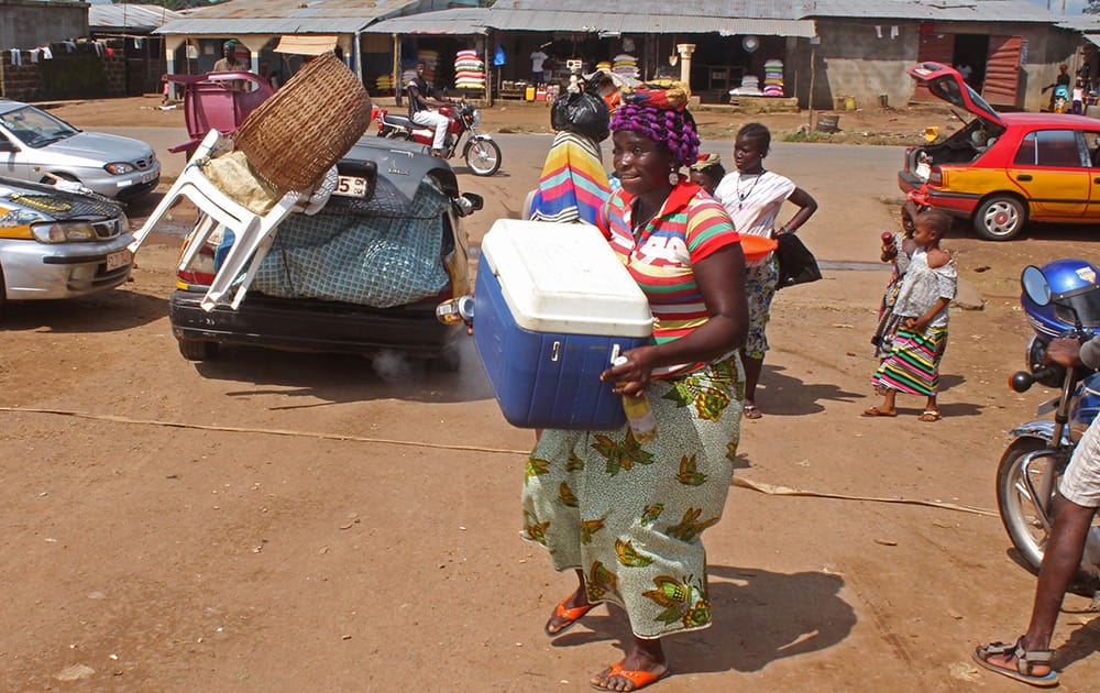 A woman carries goods at a local market in one of the largest trading areas catering for people from the Kambia District, since the Ebola virus outbreak the border has been closed with the local population`s movement stopped in an attempt to stop the virus spreading at Kambia, Guinea. 