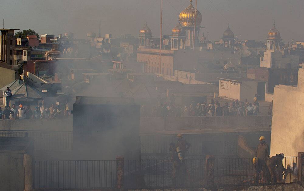 Indian firefighters try to contain a fire that broke out at Kinari Bazar, a busy market in the Chandni Chowk area of New Delhi, India.