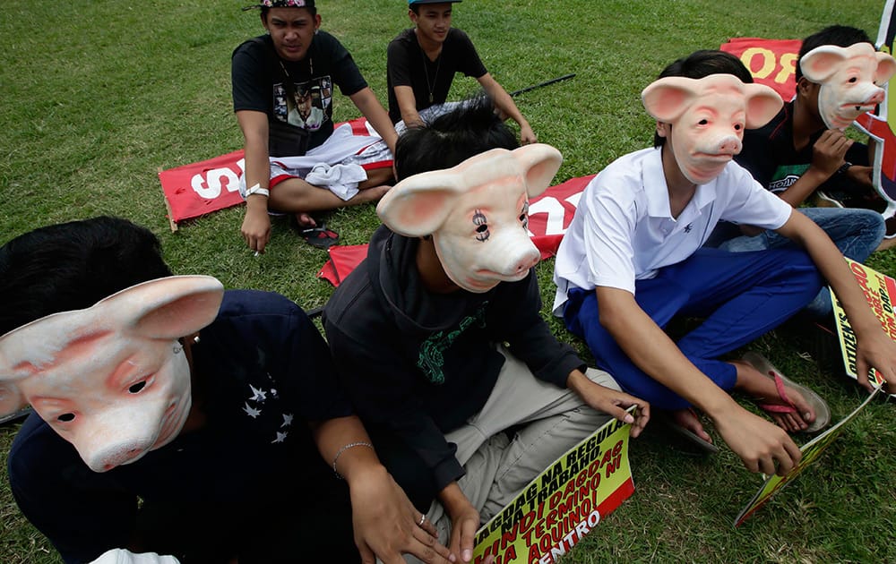 Protesters wear masks during a rally at Manila`s Rizal Park to demand the abolition of Government funds intended for the lawmakers to finance their projects known as `Pork Barrel Fund` in Manila, Philippines. 