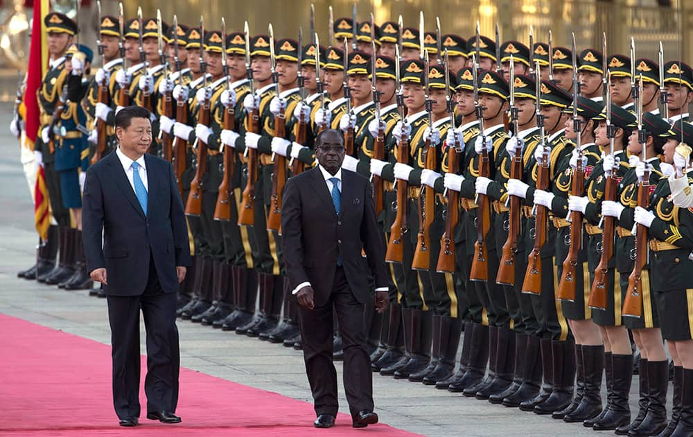 Chinese President Xi Jinping walks with Zimbabwe`s President Robert Mugabe during a welcome ceremony outside the Great Hall of the People in Beijing, China.