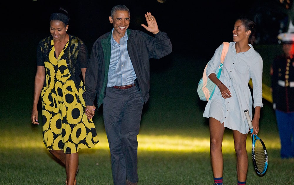 President Barack Obama and first lady Michelle Obama, walk with their daughter Malia, across the South Lawn of the White House in Washington, following their arrival on Marine One helicopter. Obama returned to Washington after spending two weeks with his family on the island of Martha`s Vineyard.