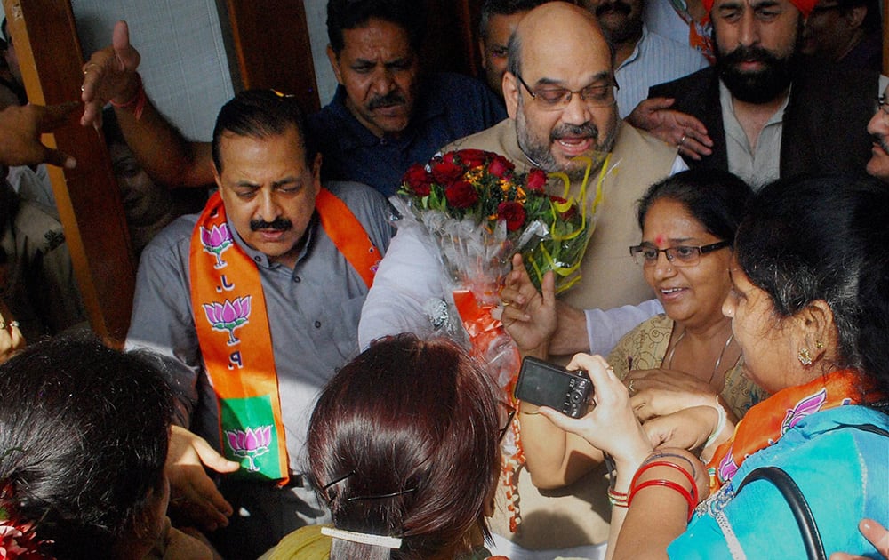 BJP National President Amit Shah (C) MoS in Prime Minister`s Office Jitendra Singh (L) being welcomed by party workers during their visit in Jammu.