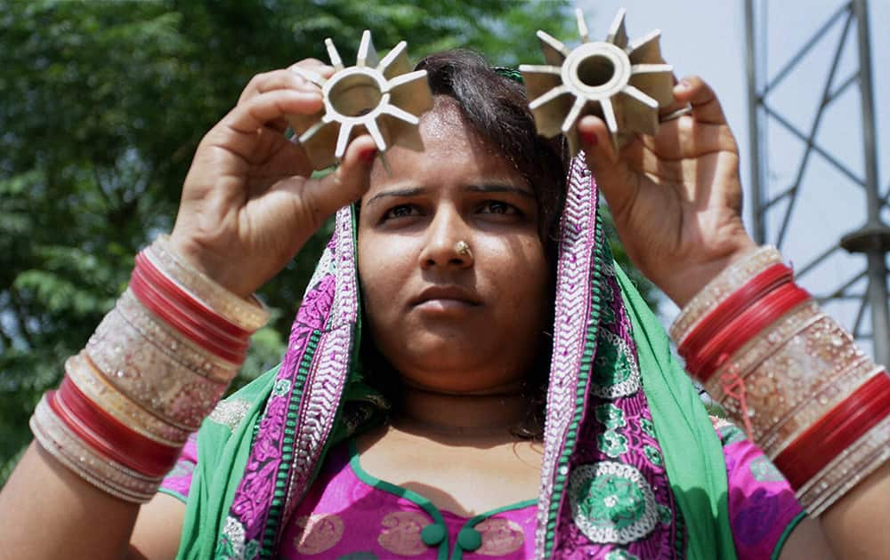 A woman shows mortar shells, allegedly fired on a residential area from Pakistan`s side at Abdullia in Jammu.