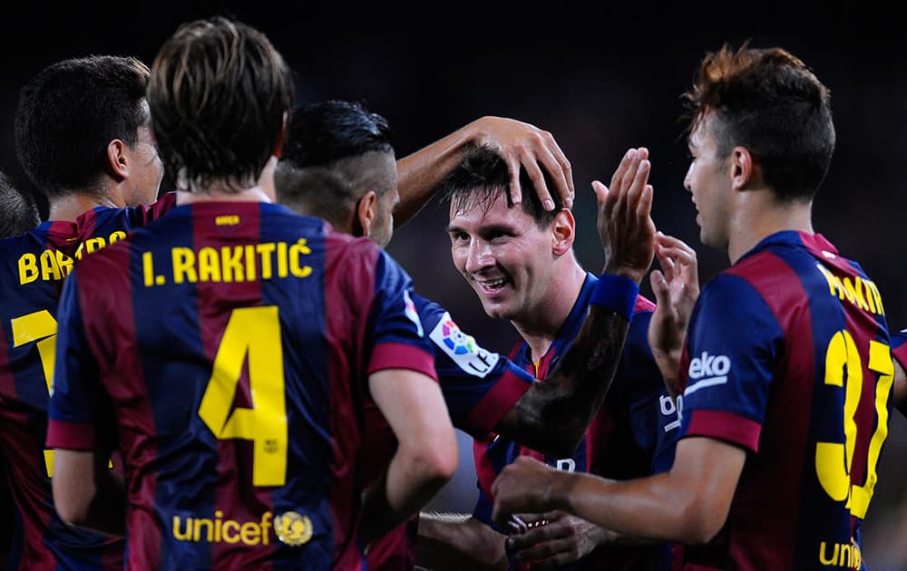 FC Barcelona`s Lionel Messi from Argentina, second right, reacts after scoring against Elche during a Spanish La Liga soccer match at the Camp Nou stadium in Barcelona, Spain.