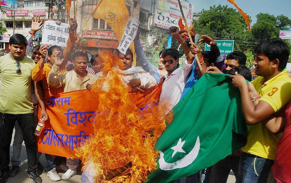 Vishva Hindu Parishad protesters burn Pakistan`s flag in a protest against firing by Pakistan in Jammu, in Allahabad.