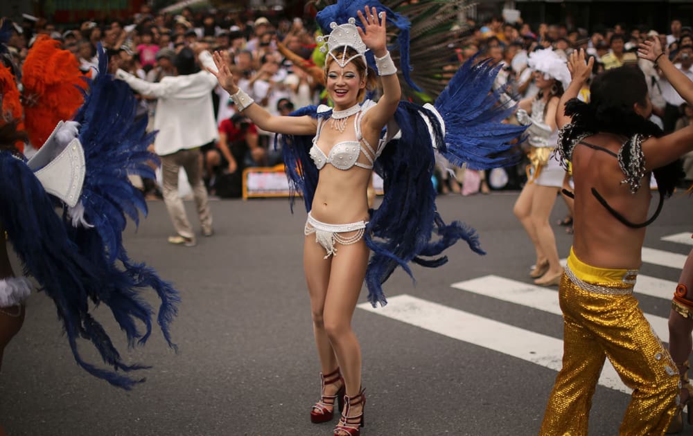 Samba dancers in colorful costumes perform through a street during the annual Asakusa Samba Carnival at Asakusa district in Tokyo.