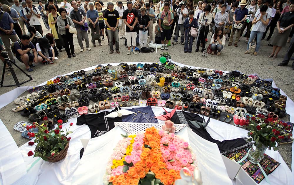 People pay a minute of silent as they pray for the war dead of children in Gaza, at Zojyoji Buddhist Temple in Tokyo.