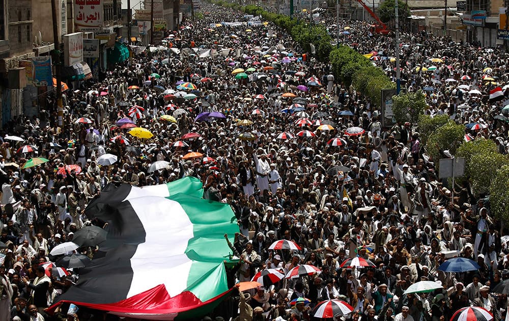 Yemeni Shiite protesters holding a large representation of a Palestinian flag chant slogans to demand the government to step down and to support Palestinians, while attending a demonstration in Sanaa, Yemen.