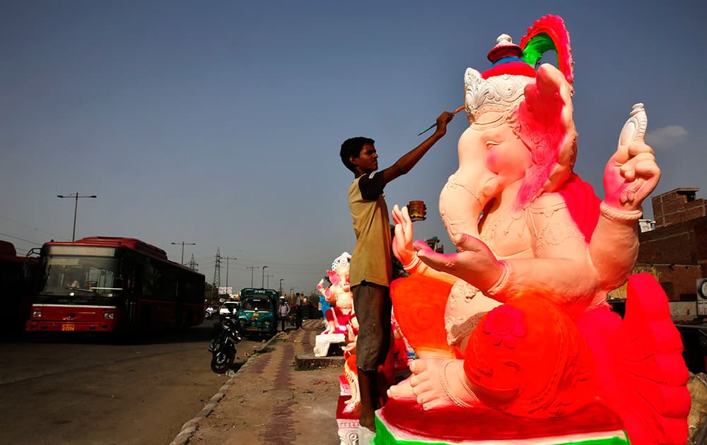 A artisan paints an idol of Hindu God Ganesha at an open workshop, ahead of Ganesha Chaturthi festival in New Delhi.