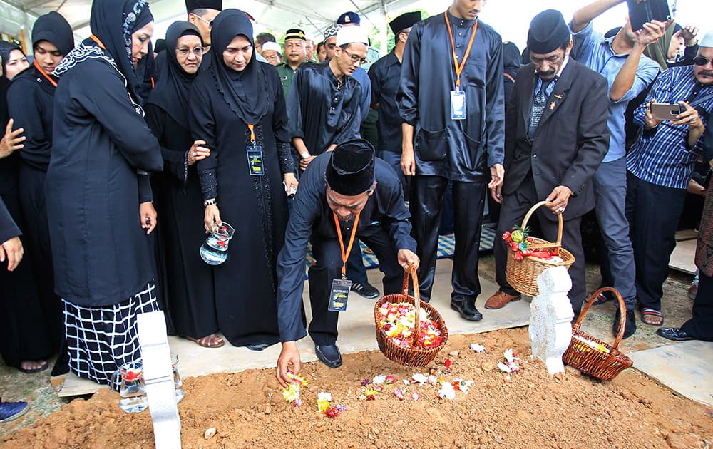 Mohamed Salleh, father of Nur Shazana, a Malaysia Airlines crew member who was among the victims onboard Flight MH17, place flowers on her grave during a burial ceremony at Taman Selatan Muslim cemetery in Putrajaya, Malaysia.