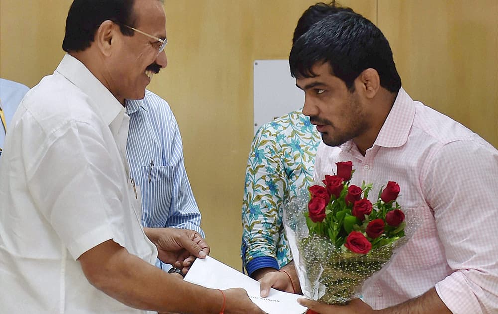 Railway Minister Sadananda Gowda felicitates CWG 2014 medal winner Sushil Kumar Solanki during a felicitation function in New Delhi.