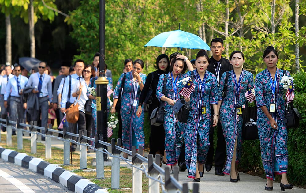 Malaysia Airlines crew members walk towards Bunga Raya Complex at Kuala Lumpur International Airport where victims` bodies of the ill-fated Malaysia Airlines Flight MH17 are flown back, in Sepang, Malaysia.