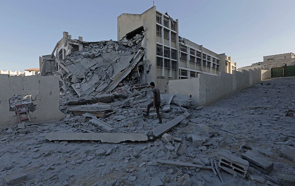 Palestinian youth inspect the damage of Ali Ibn Abi Talib government school after it was hit overnight in an Israeli strike in Gaza City, in the northern Gaza Strip.