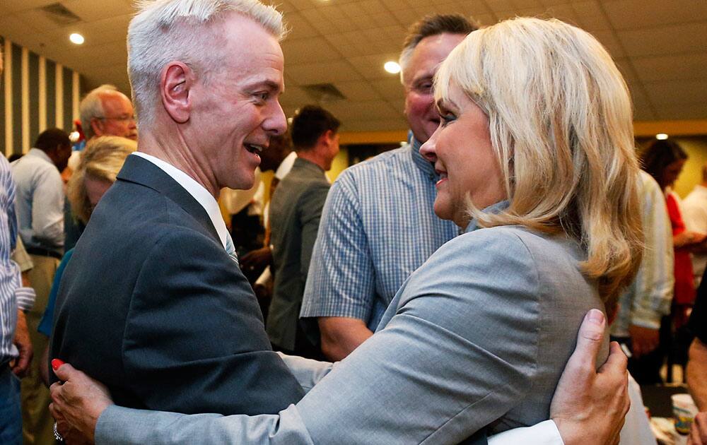 Former state Sen. Steve Russell, left, candidate for the Republican nomination to a congressional seat in central Oklahoma, embraces Oklahoma Gov. Mary Fallin, right, at his watch party in Oklahoma City.