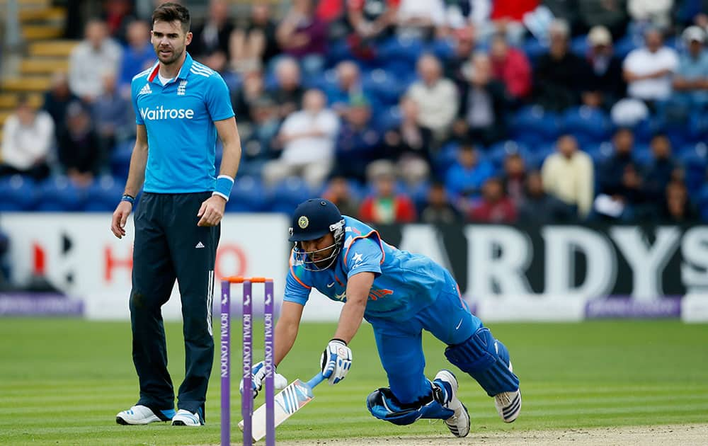 England's bowler James Anderson, left looks on as India's Rohit Sharma dives to make his crease, during their One Day International cricket match at the SWALEC cricket ground in Cardiff, Wales.