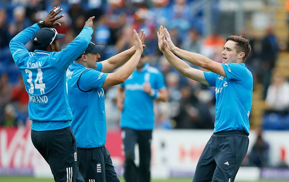 England's Chris Woakes, right, celebrates taking the wicket of India's Shikhar Dhawan, during their One Day International cricket match at the SWALEC cricket ground in Cardiff, Wales.