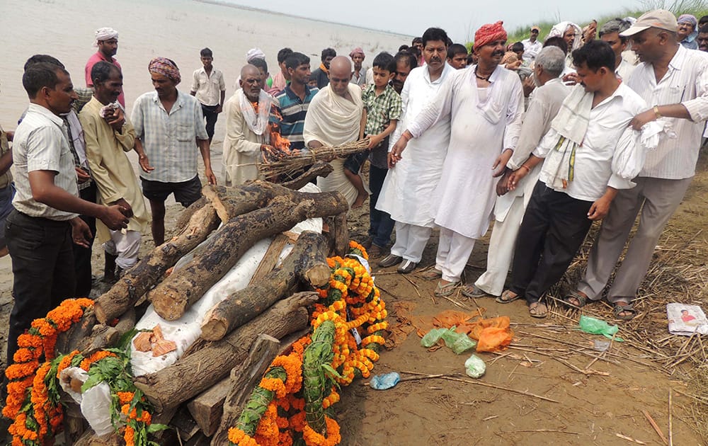 The son and father of Indian army soldier Dhananjay Kumar, killed in a gunbattle in Kashmir, together light Kumar's cremation pyre on the outskirts of Patna.