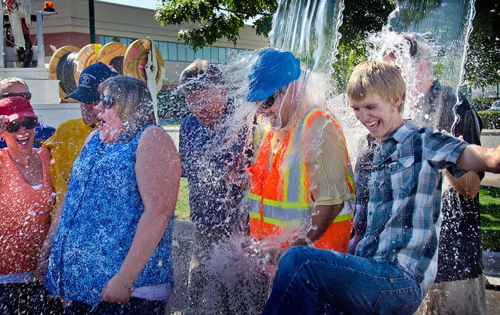 Ten Pocket iNet corporation employees, from left,including Terri McMakin, Don Gibbard, weargin hard hat, and Jake Tegtmeier, right, take the ice bucket challenge at the Walla Walla Regional Airport in Walla Walla, Wash.to benefit ALS research.