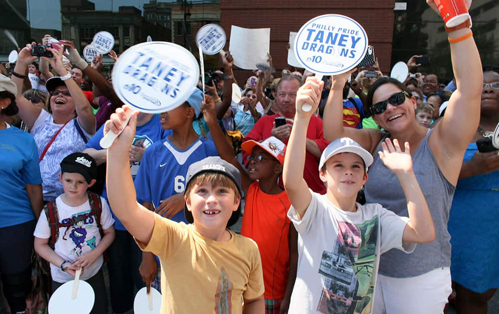 Spectators cheer for the Taney Dragons baseball team during a parade in Philadelphia.