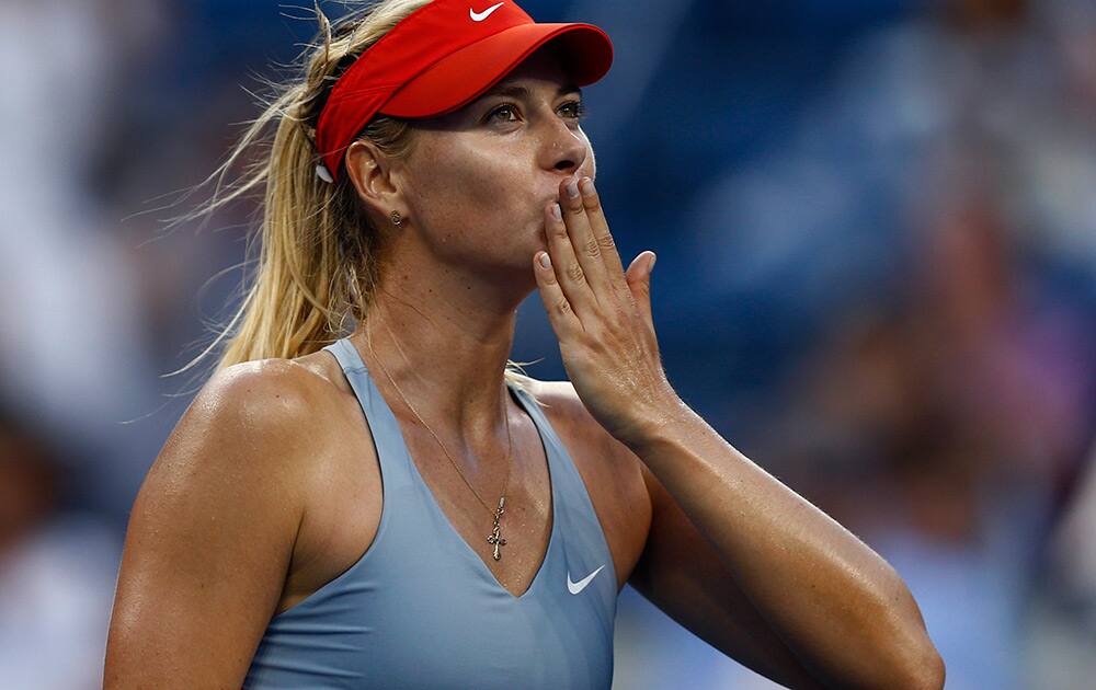 Maria Sharapova, of Russia, blows kisses to the crowd after defeating Alexandra Dulgheru, of Romania, during the second round of the 2014 U.S. Open tennis tournament in New York.