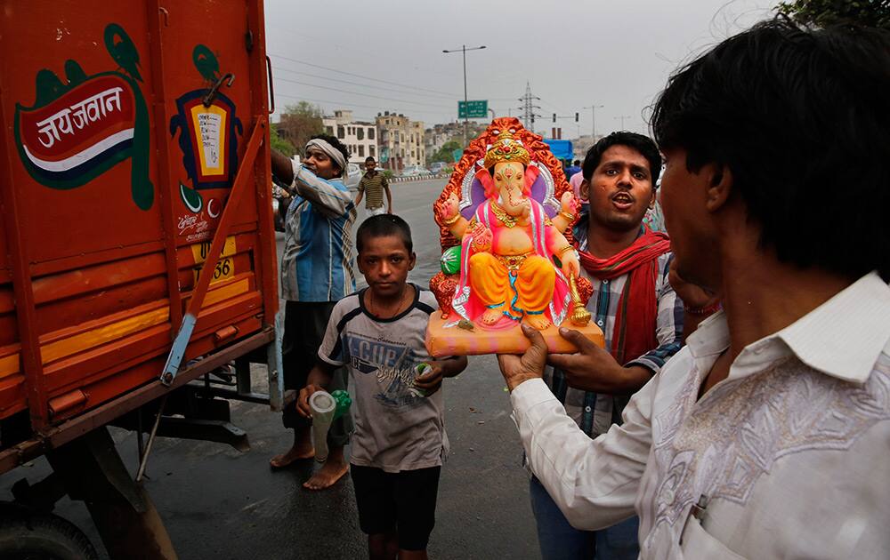 Hindu devotees carry an idol of Hindu god Ganesha to take home, ahead of Ganesh Chaturthi festival in New Delhi.