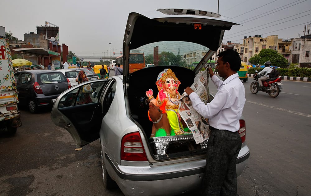 A Hindu devotee loads an idol of Hindu god Ganesha in the trunk of his car ahead of Ganesh Chaturthi festival in New Delhi.