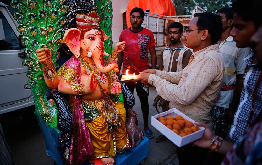 Hindu devotees perform rituals in front of an idol of Hindu god Ganesha before loading it onto a truck, ahead of Ganesh Chaturthi festival in Allahabad.