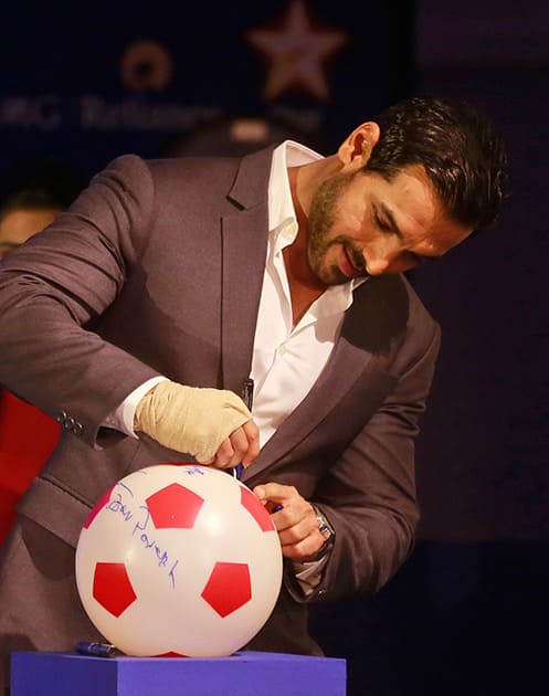 John Abraham, Bollywood actor and co-owner of NorthEast United FC, signs a soccer ball during the official launch of the Indian Super League (ISL) in Mumbai.