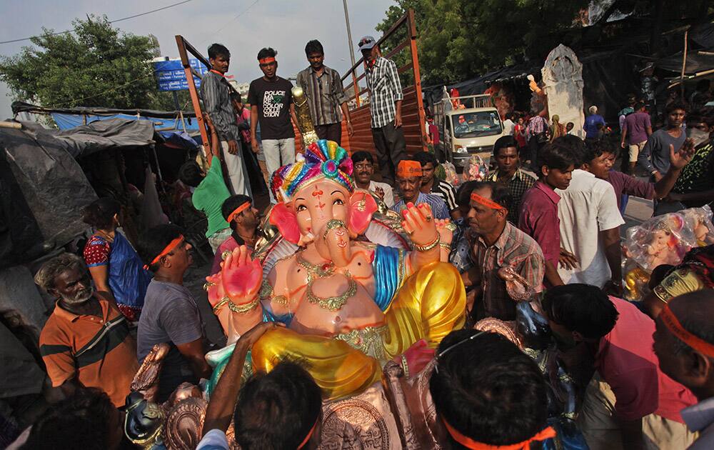 Hindu devotees load an idol of Hindu god Ganesha on the back of a truck, ahead of Ganesh Chaturthi festival in Ahmadabad.