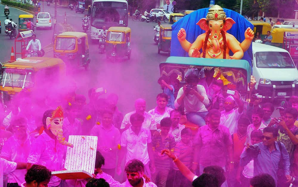 People throw colours at a Ganesh procession on the occasion of Ganesh Chaturthi in Ahmedabad.