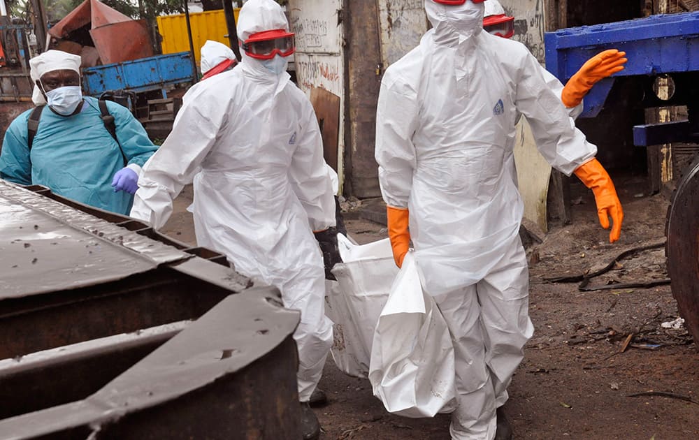 Liberian health workers carry the body of a man that they believe died from the Ebola virus in Monrovia, Liberia.