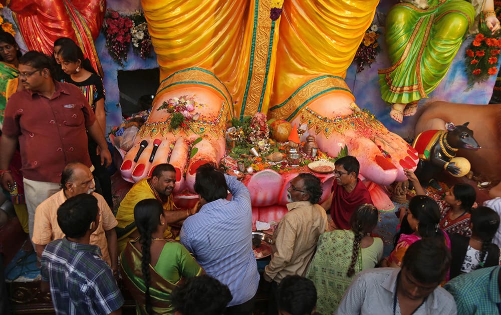 Hindu devotees perform rituals and give offerings in front of a 60 feet idol of Hindu god Ganesha on the first day of Ganesha Chaturthi festival in Hyderabad.