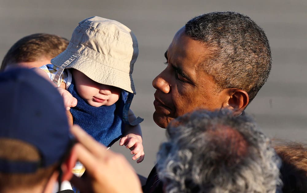 President Obama holds up four-month-old Ryan Kelley, of Richmond, R.I., while greeting a gathering shortly after arriving at T.F. Green Airport in Warwick, R.I.