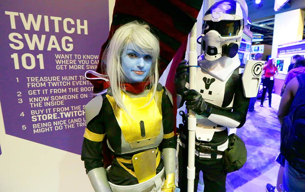 Teresa Price, left, and Steel Springer, right, dressed as hunter characters from the video game Destiny, wait in line to meet hosts of online gaming programs on the Twitch video game community at the Penny Arcade Expo, a fan-centric celebration of gaming in Seattle.