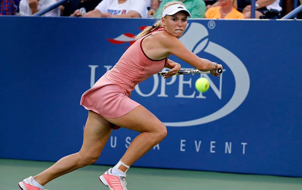 Caroline Wozniacki, of Denmark, chases down shot by Andrea Petkovic, of Germany, during the third round of the 2014 US Open tennis tournament.